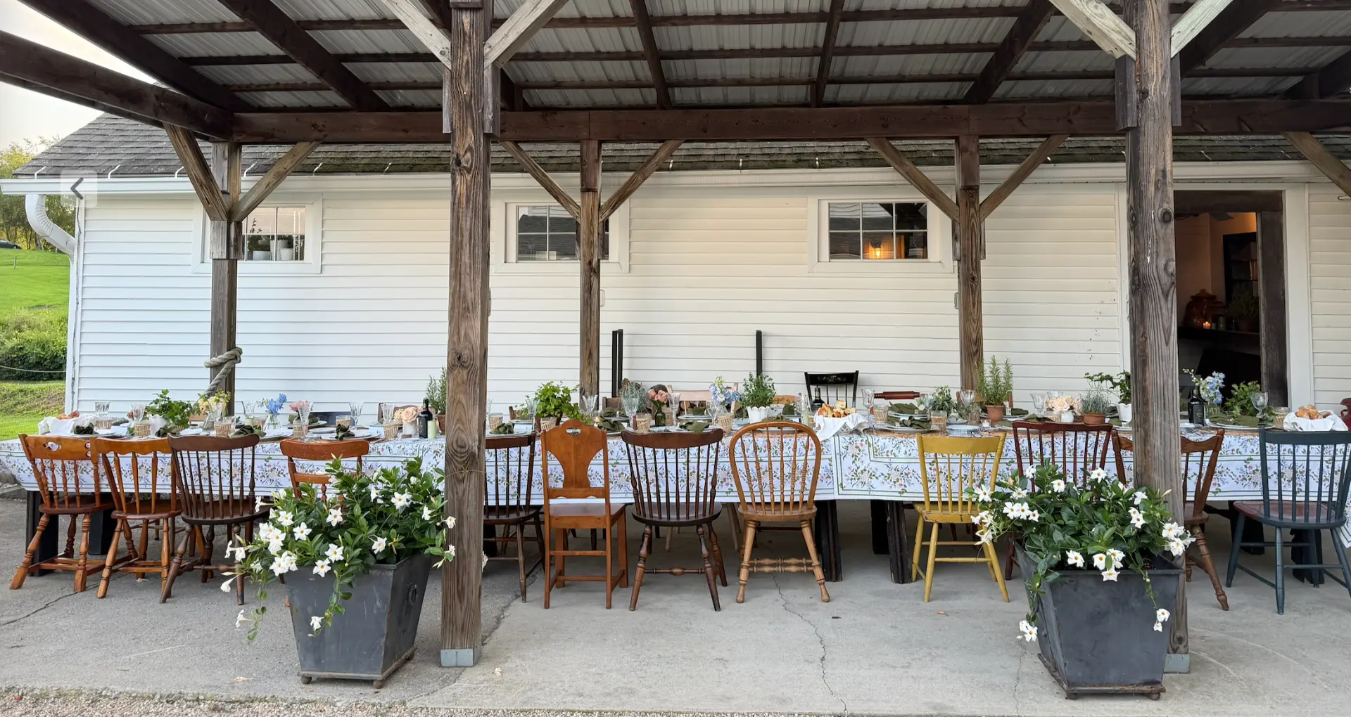 A layered table set with vintage china, glassware and candlelight
